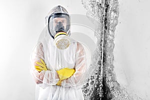 A professional disinfector in overalls processes the walls from mold. Removal of black fungus in the apartment and house. Aspergil photo