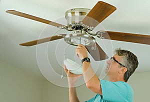 Professional or DIY home owner doing ceiling fan repair work photo