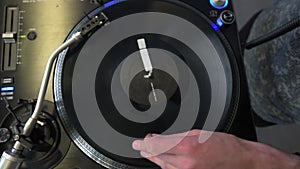 Professional DJ mixing analog vinyl record at the production studio. Entertainers hand spinning round music record at the party