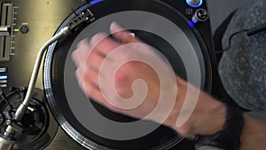 Professional DJ mixing analog vinyl record at the production studio. Entertainers hand spinning round music record at the party