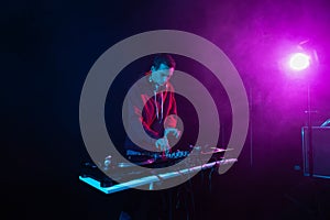 Professional DJ mixing vinyl records on a hip hop party. White male person playing music set in night club