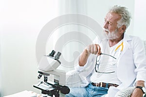 Professional doctor elderly thinking faraway look serious mood think of ways to cure the Corona virus and disease