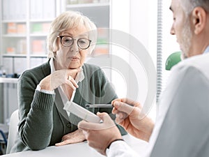 Professional doctor giving a prescription medicine to a senior patient