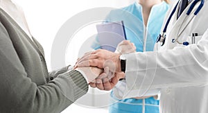 Professional doctor holding a senior patient`s hands photo