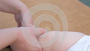 Professional doctor massagist making massage to baby on leg in clinic, closeup.