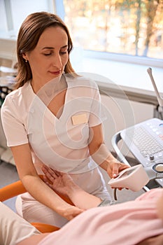 Professional doctor measuring pressure of unrecognizable pregnant woman