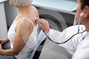 Professional doctor putting stethoscope on the skin of patient
