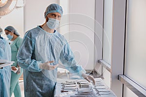 Professional doctor surgeon takes scalpel before surgery in operation room at the hospital