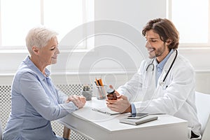 Professional doctor telling pills schedule to senior patient