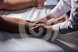 A professional doing therapeutic massage on the patient.