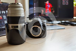 Professional dslr photo camera and big zoom lens on desk in studio