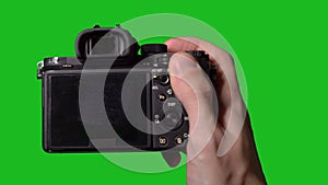 Professional DSLR photo camera with lens at green background. Chroma key.