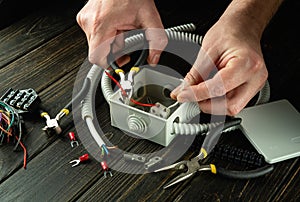 Professional electrical connection in the workshop of a master electrician. Close-up of the hands of an electrician during work.