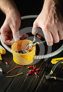 Professional electrical connection in the workshop of a master electrician. Close-up of the hands of an electrician during work.