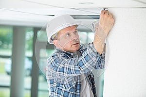 Professional electrician replacing light bulb at home