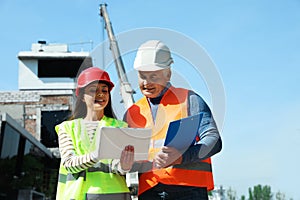 Professional engineer and foreman in safety equipment with tablet