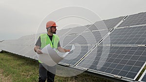 Professional engineer learning the design of the solar plant paper plan walks on ecological solar plant construction