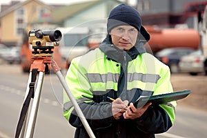 Professional engineer surveyor during road works with tacheometer theodolite tool