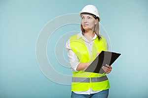 Professional engineer. A woman in a hardhat and bright jelly is using a tablet, on a blue background. Copy paste.