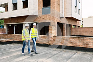 Professional engineers architect workers talking at building construction site