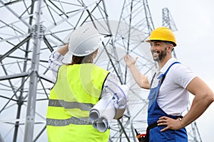 Professional engineers working on installation of electrical substation outdoors