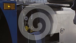 Professional equipment at the car repair center. Scene. Close up of man mechanic hands opening a cover of an inflate