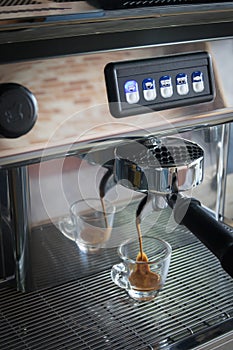 Professional espresso machine pouring strong looking fresh coffee