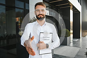 Professional estate seller with clipboard writing documents outside in front of rented house with advertising area