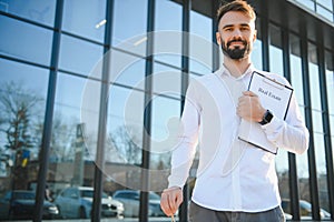 Professional estate seller with clipboard writing documents outside in front of rented house with advertising area