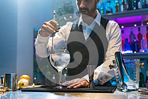 Professional expert barman making cocktail in the counter bar at party in nightclub. Nightlife concept.