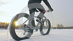 Professional extreme sportsman biker riding fat bike in outdoor. Close-up view of rear wheel. Cyclist ride in winter