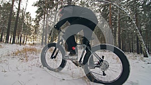 Professional extreme sportsman biker riding fat bike in outdoor. Close-up view of rear wheel. Cyclist ride in winter