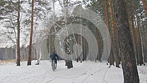 Professional extreme sportsman biker riding fat bike in outdoor. Cyclist ride in winter snow forest. Man does trial