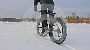 Professional extreme sportsman biker riding a fat bike in outdoors. Cyclist ride in the winter on snow ice. man does