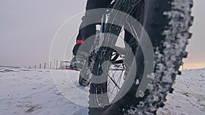 Professional extreme sportsman biker sit a fat bike in outdoor. Cyclist recline in the winter snow forest. Man walk with