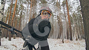 Professional extreme sportsman biker sit a fat bike in outdoor. Cyclist recline in the winter snow forest. Man walk with