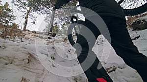 Professional extreme sportsman biker to bear fat bike to up mountain in outdoor. Cyclist walk in winter snow forest. Man