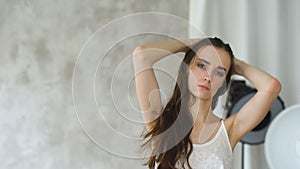 Professional fashion model posing and looking into camera. Woman show poses and emotions closeup