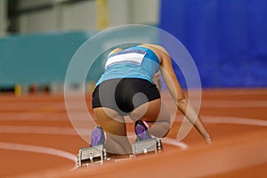 Professional female athlete at the start of sprint