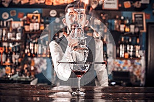 Professional Female bartender creates a cocktail on the bar