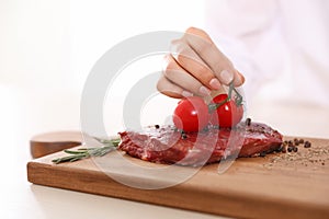 Professional female chef cooking meat