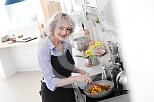 Professional female chef cooking vegetables