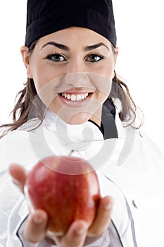 Professional female chef showing fresh apple