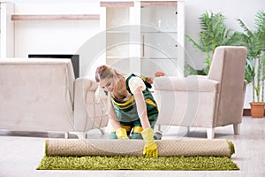 The professional female cleaner cleaning carpet