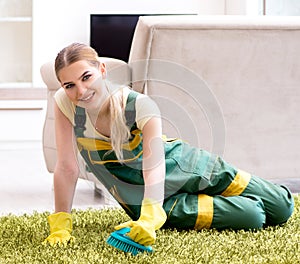 Professional female cleaner cleaning carpet