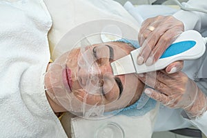 professional female cosmetologist in a mask makes facial contour injections to female patient