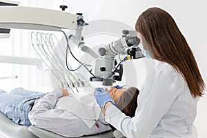 Professional female dentist using modern technologies in treatment