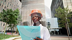 Professional female engineer in hardhat reading documents