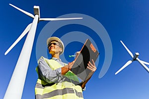 Professional female engineer working in a wind turbine field.