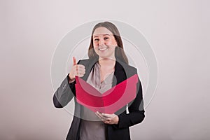 Professional female gesturing a thumbs up holding a red file folder